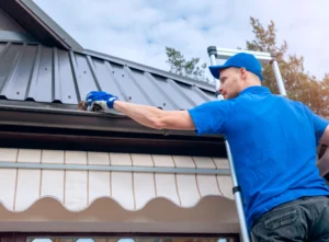 worker with tshirt blue repairing dark gutter worker with tshirt blue repairing dark gutter